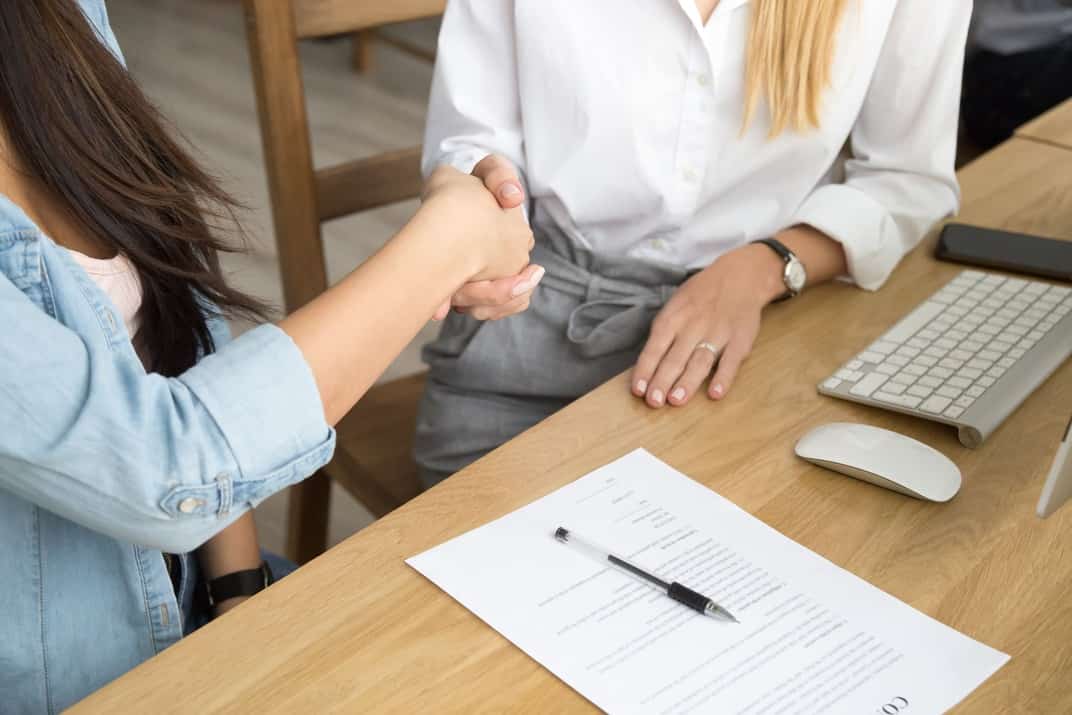 two-women-partners-handshaking-after-signing-business-contract-at-meeting-1
